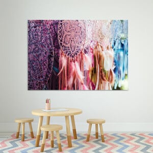 Flerfärgad drömfångare. Original av god kvalitet, hängde på en vägg ovanför ett bord och tre stolar i ett vardagsrum