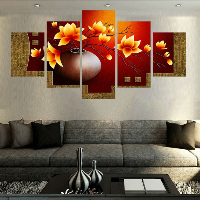 Zen-målning med orangefärgade blommor som hänger ovanför en grå soffa