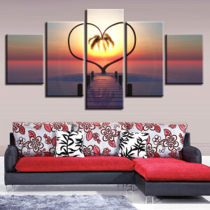 5-delad Jungle-målning hjärta av palmer i solnedgång installerad ovanför en röd och vit tryckt soffa