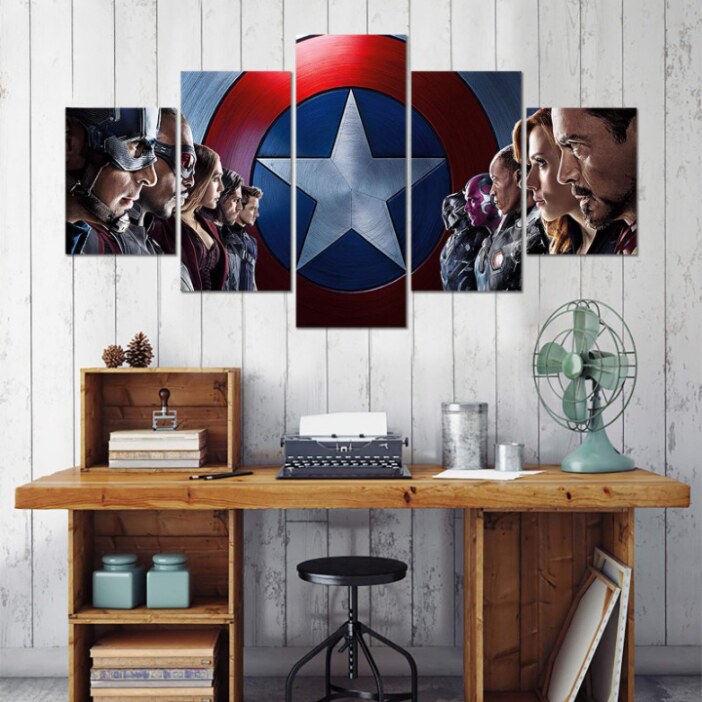 på en grå bakgrund en femdelad tavla som föreställer Marvel Avengers-hjältarna uppradade och vända mot varandra, framför Captain Americas chef. Under brädet ett skrivbord av trä.
