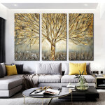 Triptyk natur med gyllene träd installerad i ett vardagsrum ovanför en soffa